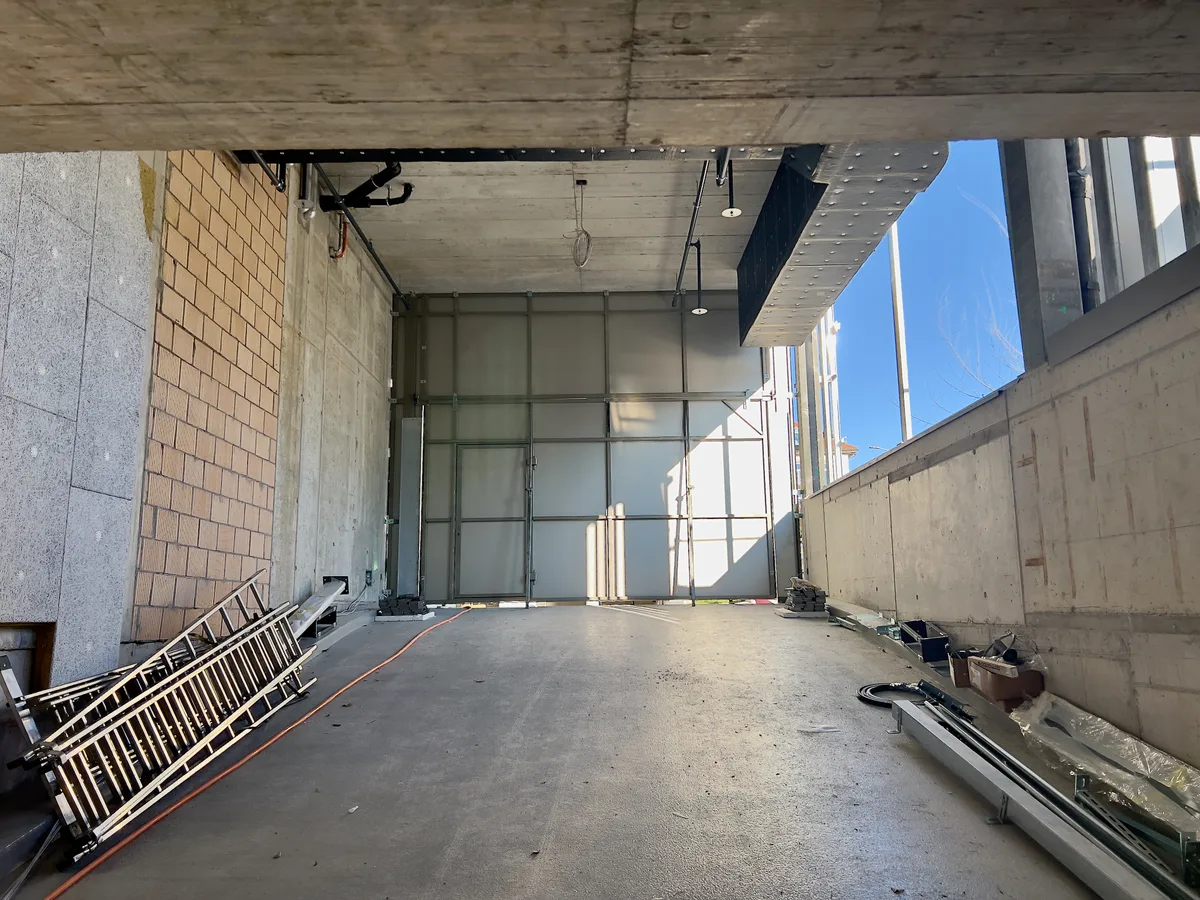 Man sieht die Ausfahrt aus einer Tiefgarage von innen. Das Tor ist zu.